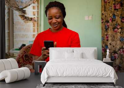 beautiful african woman gets excited about what saw on her cellphone Wall mural