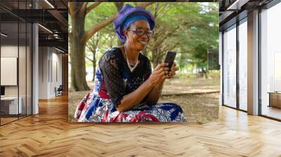 beautiful Senior woman using mobile phone at park Wall mural