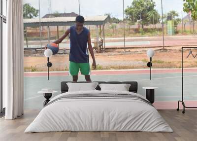 Picture of young focused african basketball player practicing outdoor. Fit afro man in motion and movement. athletic and sport lifestyle concept Wall mural