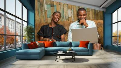 two african young businessmen seriously working with their mobile phone and laptop feeling about what they saw on their device Wall mural