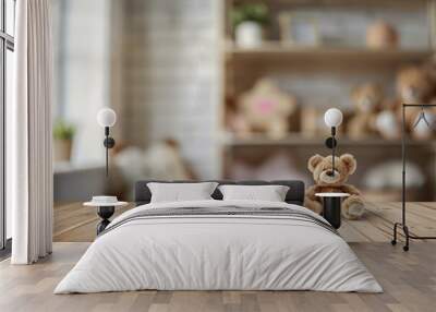 A cute bear sitting on a wooden table with a blurred background of shelves filled with soft toys and plants Wall mural