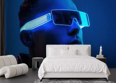 Blue light reflection stylish man in sunglasses against vibrant blue background, fashionable travel accessory Wall mural