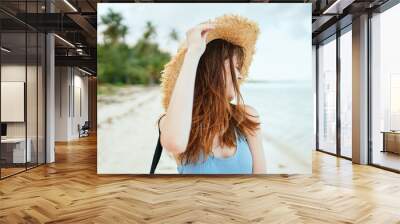 cheerful woman in a beach hat by the ocean island summer Wall mural