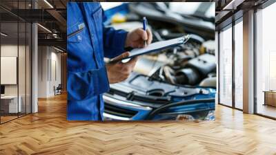 Mechanic inspecting vehicle engine with clipboard in hand, wearing blue work uniform Wall mural