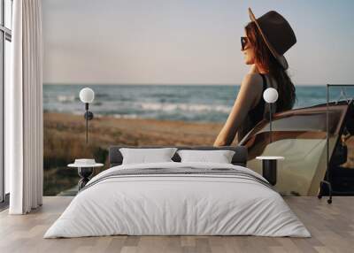 pretty woman in sunglasses near the car on the beach travel lifestyle Wall mural