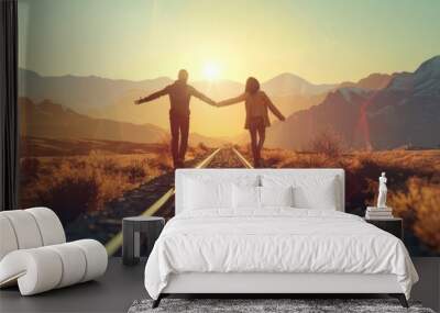 Romantic couple holding hands on train track at sunset in beautiful travel destination Wall mural