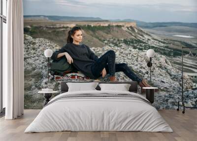 solitude on the summit woman resting with bag and hat on mountain edge Wall mural