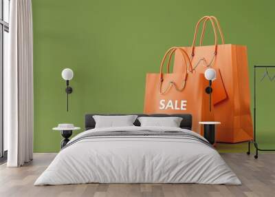 Two vibrant orange shopping bags with sale tags on green background, symbolizing business and consumerism Wall mural