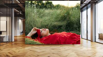 woman in red dress lying on the grass fresh air nature romance Wall mural