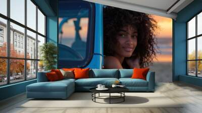 Woman with curly hair relaxing in blue jeep during sunset adventure travel beauty scene Wall mural