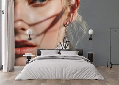 Fashion beauty portrait of young beautiful woman with shadows. Focus on the earring Wall mural