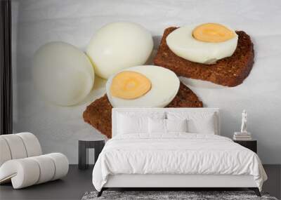 Eggs and two pieces of rye bread on the white napkin Wall mural