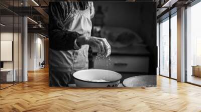  Closeup photo of baker making dough for bread. Hands of an old woman at work with the dough. Retro look.  Black and white photo of the hands of a woman Wall mural