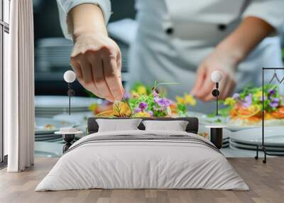 A chef in a professional kitchen carefully adds the finishing touch to dishes before serving them. Chef hands decorating a plate in a kitchen of a restaurant.  Wall mural