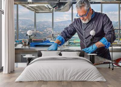 A cook cuts up a fish. Tuna Wall mural