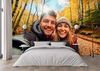 Attractive couple taking a selfie in a forest in autumn Wall mural