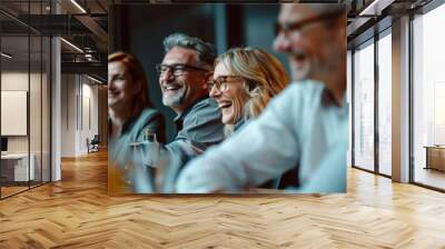 A group of people, smiling and laughing together, creating a lively and joyous atmosphere in what appears to be an office or meeting setting. Wall mural