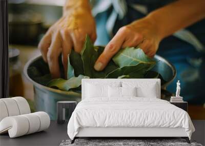 A pair of hands working with bay leaves in the kitchen, demonstrating a moment of precise culinary preparation with natural light highlighting the scene. Wall mural