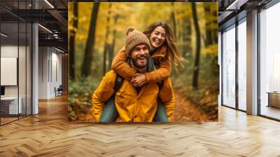 Happy couple piggybacking in a forest one autumn afternoon Wall mural