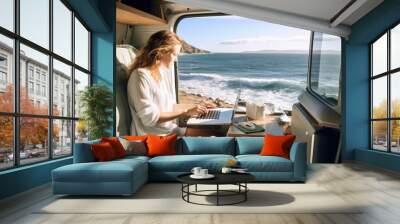 Independent woman sitting inside a camper van in using a laptop. Living and working inside camper van vehicle in travel and digital nomad free lifestyle.  Wall mural