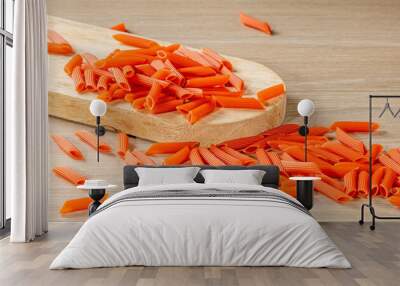 Italian pasta in bright red color is scattered on the kitchen table Wall mural