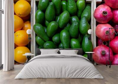 Juicy fruits of tropical avocados, oranges and pomegranates. Wall mural