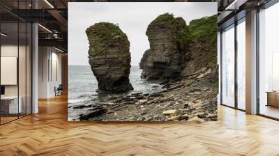 There are two large rock formations situated on the shore of a body of water Wall mural