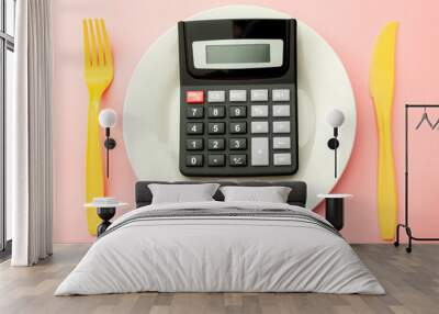 Calculate expensive food spending costs, counting calories and weight loss program concept with calculator onn empty plate, yellow fork and knife isolated on pink background Wall mural