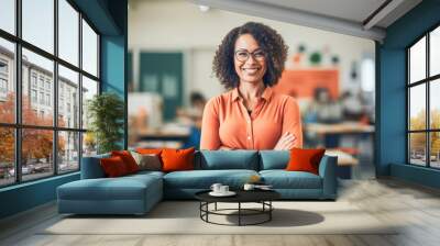 Portrait of smiling woman teacher posing with arms crossed in classroom looking at camera. Confident happy female educator.  Wall mural