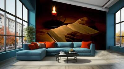 Reading the bible by candle light Wall mural