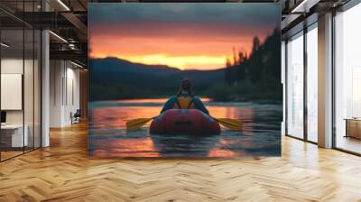 A bearded man in a red kayak glides through a mountain river as the sun sets Wall mural