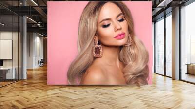 Ombre blond wavy hairstyle. Beauty fashion blonde woman portrait. Beautiful girl model with makeup, long healthy hair style posing isolated on studio pink background. Wall mural