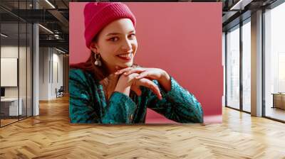 Close up portrait of young beautiful happy smiling fashion model wearing trendy pink, fuchsia color beanie hat, earrings, green sequin blazer. Spring fashion conception. Copy, empty space for text Wall mural