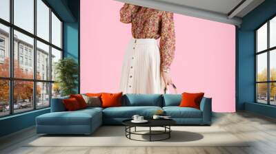 Full-length studio fashion portrait of young elegant happy smiling woman wearing trendy spring outfit: floral print blouse, white pleated skirt, ankle boots, holding stylish green faux leather bag Wall mural