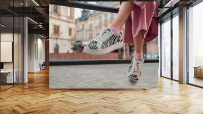 Trendy fashion details: woman wearing stylish sneakers with zebra print, posing in street of European city. Copy, empty space for text Wall mural