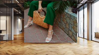 Trendy summer straw wicker top handle bag, white strap sandals in stylish female outfit. Fashion details. Copy, empty space for text Wall mural