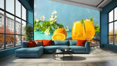 Two glass of orange ice drink with fresh mint on wooden turquoise table surface. Alcoholic non-alcoholic drink-beverage. Wall mural