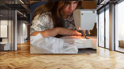 Woman use sewing machine needle Close up tailor Tailoring Process working Caucasian girl Dressmaker Female hands stitching clothing fashion designer at home beautiful. Wall mural