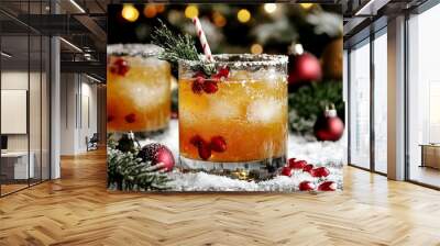 Two cocktails are standing on snow with pomegranate seeds and a sprig of pine, with christmas ornaments and lights out of focus in the background Wall mural