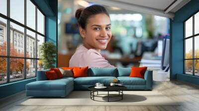 Young professional woman smiling while working in office Wall mural