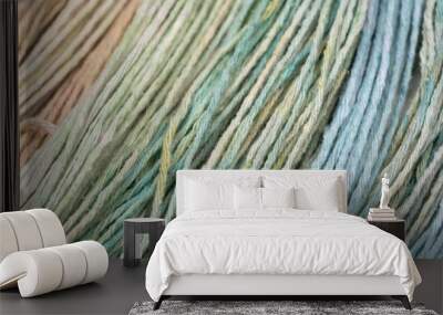 Multicolored yarn, showcasing a spectrum of green, beige, and blue hues. The fine, soft texture of the threads is captured in detail, highlighting the natural fibers and artisanal quality  Wall mural