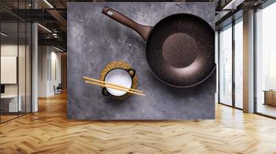 Wok Pan Empty with Wooden Chopsticks on Dark Background. Top View. Wall mural