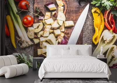 Chopped eggplant on wooden cutting board with knife and various vegetarian cooking ingredients for healthy eating , top view. Balkan cuisine concept Wall mural