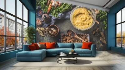 Cooking preparation of mashed potato casserole with meat with ingredients on dark rustic kitchen table background. Top view. Tasty home cuisine Wall mural