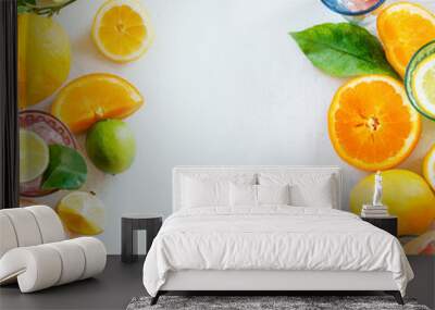 Frame of various citrus fruits with green leaves on white table, top view. Healthy lifestyle. Ingredients. Vitamin. Halves and slices. Layout Wall mural