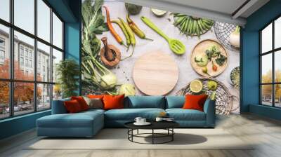 Fresh green food cooking concept. Various seasonal vegetables on table with kitchen tools and spoon , top view. Round wooden cutting board copy space. Healthy organic food. Paleo dieting. Vegetarian Wall mural