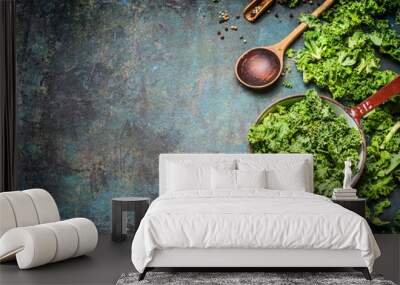 Fresh kale in cooking pot with wooden spoon on  rustic background, top view, border. Healthy food or diet nutrition concept. Wall mural