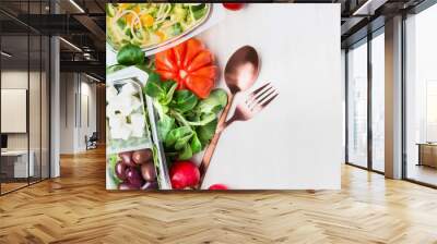 Healthy eating with salad and cutlery on white wooden background, top view. Clean and dieting food, lunch boxes Wall mural