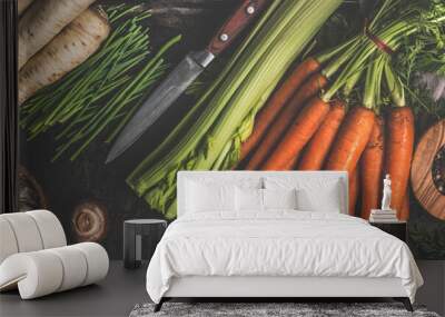 Various vegetables and kitchen utensils on dark rustic kitchen table: Carrots, garlic, mushrooms, celery and parsnip. Healthy lifestyle with vegetarian food. Top view. Banner. Wall mural