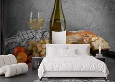 Board with cheese, bottle of wine and fruits on grey background Wall mural